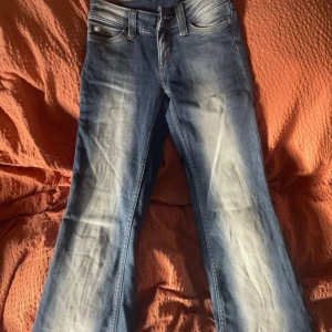 Kvarg jeans från Cheap Monday - Snygga blå jeans från Cheap Monday med bootcut passform och coolt sliten tvätt. Klassisk femficksmodell med logga och döskallepatch bak i midjan. Jeansen har låg midja och är tillverkade i mjukt denimtyg som sitter skönt hela dagen. Storlek 24/30 passar perfekt på mig som är 165. Enbart använda 1 gång
