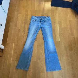 Diesel Louvely bootcut jeans ljusblå - Snygga ljusblå jeans från Diesel, modell Louvely. Klassisk femficksdesign med bootcut-ben och slitna detaljer. Jeansen har normal midja och är tillverkade i stretchigt denim för extra komfort. Perfekta för dig som gillar en avslappnad men trendig look.