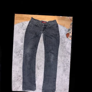 Grå vintage jeans från Rock & Republic - Snygga grå jeans från Rock & Republic med raka ben och coola bakfickor med kontrastsömmar. Jeansen har klassisk femficksdesign, ultra låg midja och är tillverkade i stretchig denim för skön passform. Perfekta för dig som gillar en stilren men edgy/vintage look! Passar storlek 32-34/ xs