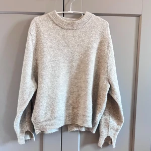 Grå stickad tröja - Fin tröja i bra skick med slitsdetaljer vid armarna och på baksidan av tröjan🥰