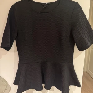 Svart volangtröja - Fin mönstrad volangtröja, använd fåtal gånger. Den är i ett mönstrat material och väldigt skön i materialet. Väldigt höstig och fin som man både kan klä upp och ner💞