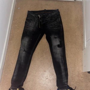 Dsquared2 jeans - Snygga svarta skinny jeans från Dsquared2 med slitna detaljer och cool tvätt. Byxorna har klassisk femficksdesign, dragkedja och Dsquared2-logga på bakfickan. Perfekta för dig som gillar streetstyle och vill sticka ut med en edgy look.