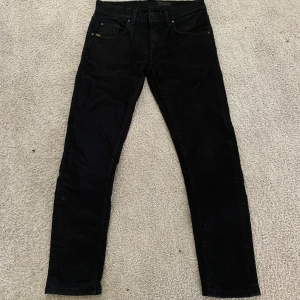 Jeans från tiger of Sweden  - Svarta slim fit jeans från tiger of sweden. Jeansen har raka ben och är tillverkade i ett stretchigt bomullsmaterial för en bekväm passform. Perfekta för dig som gillar en stilren och enkel look. Priset är inte skrivet i sten!