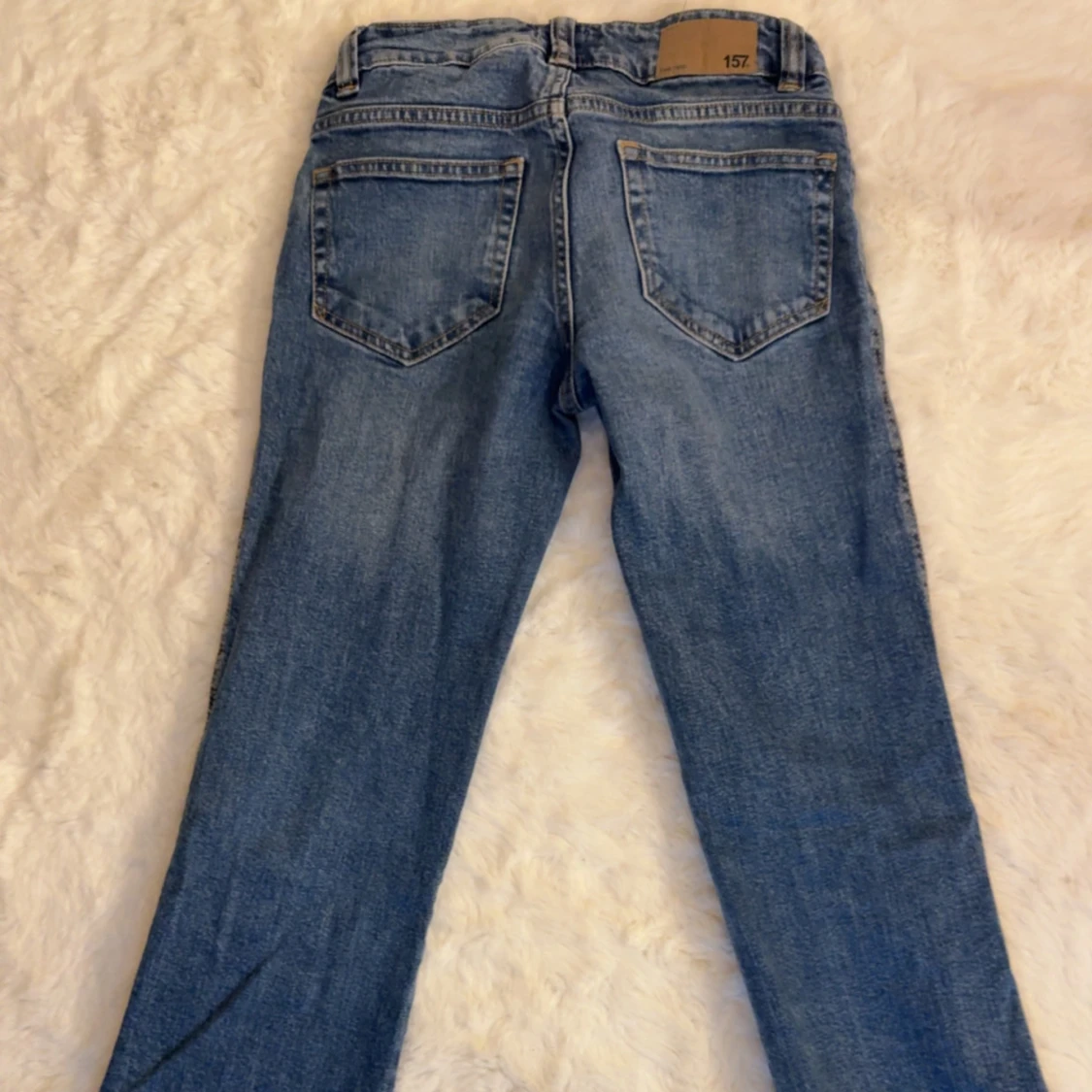 Blå jeans med slitningar och stora fickor - 1