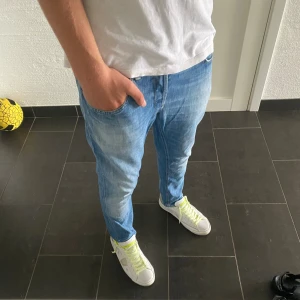 Dondup George  - Säljer ett par skinny fit jeans från dondup i ljusblå denim. Jag är 185 och väger 77kg och de sitter kort på mig. Byxorna har klassisk femficksdesign, smal passform och snygga slitningar framtill. Perfekta för dig som gillar en tajt look och vill ha ett par stilrena jeans i bomull.