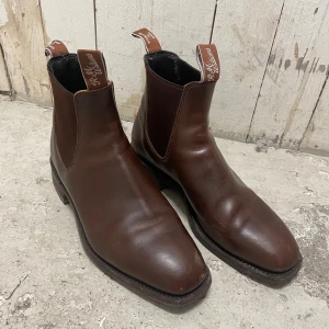 Bruna Chelsea boots från R.M. Williams - Snygga bruna Chelsea boots från R.M. Williams i slätt skinn. Storlek 7 och i perfekt skick, bara några små märken fram på tån. Kartong finns. 
