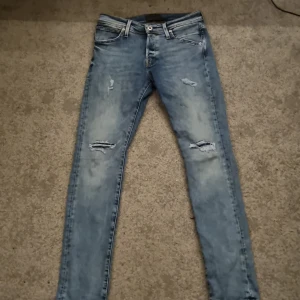 Jack & Jones jeans - Ljusblå jeans från Jack & Jones med snygga slitningar på framsidan. St 30/32 men skulle säga att den passar dig som har  28/32 också. Hör av er vid eventuella frågor.