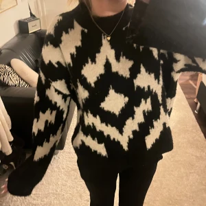 Svartvit stickad tröja med mönster - Säljer en svart och vit stickad tröja med grafiskt mönster. Tröjan är lite nopprig! 