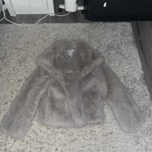Grå fluffig pälsjacka med knappar - Säljer en grå fusk pälsjacka från dressy, den är i bra skick men jag har bytt ut knapparna på den. Skriv för mer bilder och prisförslag om ni vill 