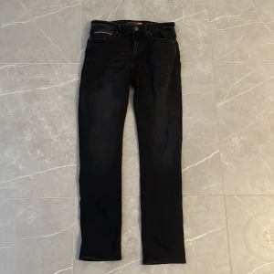 Replay svarta jeans Anbass slim fit - Svarta jeans från Replay, modell Anbass med slim fit. Klassisk femficksdesign, svarta sömmar och Replay-logga på bakfickan. Jeansen har en smal passform och är tillverkade i stretchigt jeansmaterial för extra komfort.