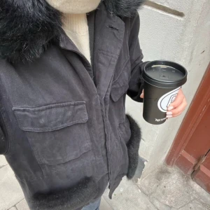 Custommade jacka - Snygg svart jacka med stora fluffiga pälsdetaljer vid krage och fickor. Jackan har två stora bröstfickor med lock, knappar vid ärmslut och rak passform. Stilsäker och trendig look. Pris går att diskutera. Den är i bra skick. Storlek S/M