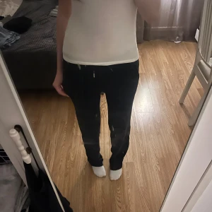 Mörkblå mjukisbyxor Juicy Couture XS - Säljer ett par mörkblå mjukisbyxor från Juicy Couture i storlek XS. Byxorna har raka ben, snörning i midjan och silverfärgade knappar bak. Mjukt velourmaterial och broderad Juicy-logga vid fickan. Perfekta för chill dagar. Skriv om ni har några funderingar 💕😊