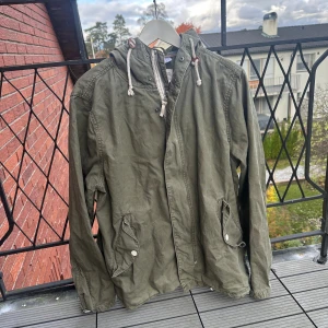 Grön jacka - Säljer en riktigt snygg militärgrön vindjacka. Den är i fint skick utan några defekter. 8/10 skick. Pris kan diskuteras, skriv vid intresse! 