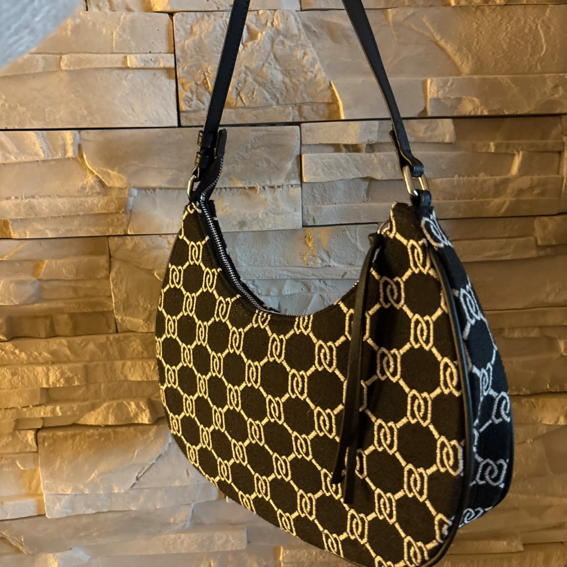 Svart och vit axelväska med mönster