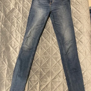 Blå skinny jeans Abercrombie & Fitch - Snygga blå jeans från Abercrombie & Fitch i modellen skinny med klassisk femficksdesign och gul kontrastsöm på bakfickan. Jeansen har normal midja och är tillverkade i mjukt denim-material som sitter tight längs benen.
