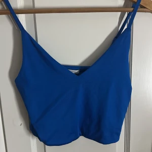Blå croppad linnetopp med v-ringning - Snygg blå linnetopp med croppad passform och v-ringad hals. Tunt, mjukt material och smala axelband som är justerbara för bästa komfort. Jätteskön och bra kvalité på denna topp☺️ Användt 4 gånger ‼️