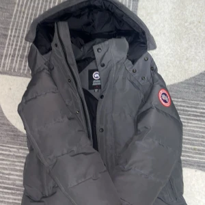 Mörkgrå dunjacka från Canada Goose - Säljer en mörkgrå dunjacka från Canada Goose. Ganska ny, med päls. Passar perfekt för en m storlek 