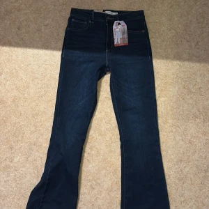 Levi's 726 Flare jeans mörkblå - Säljer ett par Levi's 726 Flare jeans, mörk tvätt. aldrig använda, och alla lappar är kvar, de är högmidjade, jag är 158cm o dom slutar precis under naveln på mig! de är även stretchiga.