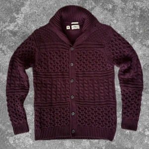 Vinröd stickad cardigan  - Väldigt skön, varm och snygg perfekt i det kyllliga vädret. Måtten: A=53cm B=48cm C=40cm D=66cm