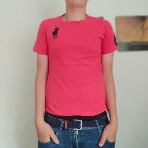 Ralph Lauren T-shirt  - Bra skick har en liten liten fläck under bröstet som man inte märker. Går bort i tvätten. Där av de låga priser. Kolla profilen för mer Ralph Lauren kläder och följ gärna också.