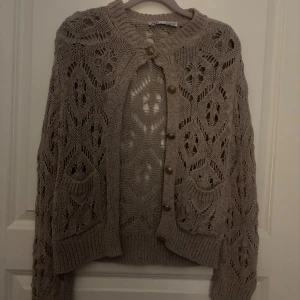 Stickad kofta från Zara - Säljer en beige/brun stickad kofta från Zara i storlek S. Stockholmsstil super fin!! Kommer inte till användning längre