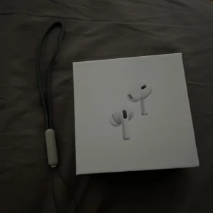 AirPod Pro 2nd Generation with MagSafe Charging Case - Säljer ett par Apple AirPod Pro 2nd Generation med MagSafe-laddningsetui. Komplett med originalförpackning, extra öronproppar och laddkabel. Allt i mycket fint skick, inga synliga repor eller skador. Perfekt för trådlös musik och samtal.