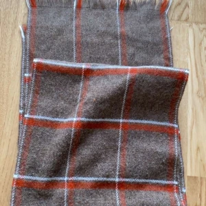Brun rutig halsduk med orange detaljer - Snygg brun halsduk med rutigt mönster i orange och vita linjer. Mjuk och varm känsla, perfekt att slänga över axlarna när det är kallt ute. Fransar i ändarna ger en chill vibe. Passar dig som gillar klassisk stil med en twist.