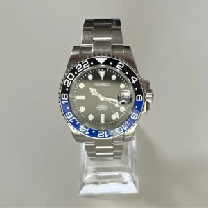 Automatisk klocka från Seiko - Säljer en stilren automatisk klocka från Seiko med en silverfärgad länk och en svart urtavla. Länkar fås med, bandet kan även mikrojusteras. 