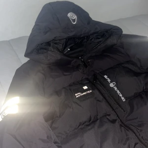 Svart Sail Racing jacka  - Säljer min Sail Racing Antarctica Down Jacket i storlek L. Jackan är helt oanvänd utomhus – endast provad inomhus. Nypris ligger på cirka 10 000 kr (från Sail Racing).  Supervarm och lätt dunjacka i exklusiv Sail Racing-kvalitet. Perfekt för vintern – vattentåligt material och snygg passform.  💰 Pris: 3 700 kr 📦 Kan skickas eller mötas upp beroende på var du bor