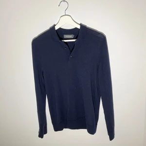 Långärmad pikétröja marinblå merinoull - Snygg marinblå långärmad pikétröja från Dressmann i mjuk merinoull. Storlek S