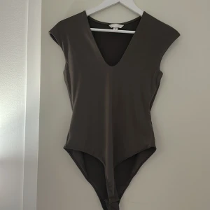 Svart v-ringad body - Säljer denna skit snygga bodyn från H&M, aldrig använd endast testad, passar till allting, storlek S