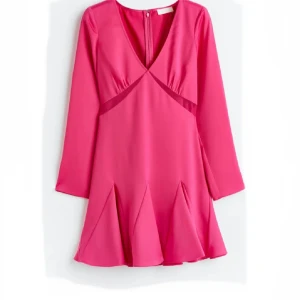 Rosa kort klänning med v-ringning - Supersnygg rosa kortklänning med v-ringning och långa ärmar. Klänningen har markerad midja och coola veckade detaljer i kjolen som ger extra volym. Tillverkad i ett lätt, glansigt material som känns lyxigt. Perfekt för dig som vill sticka ut med färg! Under bysten är det lite genomskinligt tyg vilket jag tycker är skitsnyggt! Den har aldrig kommit till användning tyvärr eftersom den är väldigt fin!