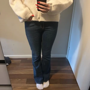 bootcut jeans - Snygga blå jeans med bootcut-modell och klassisk femficksdesign. Jeansen har normal midja och är tillverkade i ett stretchigt denimtyg som sitter skönt och formar sig efter kroppen. Perfekta för dig som gillar en tidlös och trendig look.