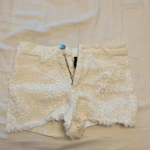 Vita jeansshorts med spets - Jättefin shorts med spets på framsidan i storlek 34. Aldrig använda, så perfekt skick. Midjemåttet rakt över är 33cm.