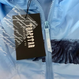 Blå trapstar vindjacka  - En snygg blå trapstar vindjacka med snygga detaljer som syns mycket på nätet, den passar mycket fint till många stilar. Den är i storlek S men passar även M