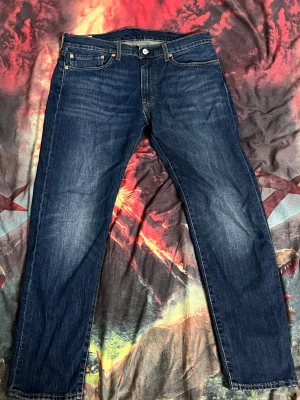 Levi's 502 Premium jeans - Snygga Levi's Premium 502 jeans i klassisk mörkblå tvätt med raka ben och fem fickor. Jeansen har gul kontrastsöm, läderpatch bak och är tillverkade i slitstarkt bomullsjeansmaterial. Passar dig som gillar en tidlös och clean look. Självklart tvättas de innan de fraktas. Skriv gärna om du vill diskutera priset!