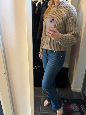 Beige stickad tröja från H&M - Säljer en chunky stickad tröja från H&M i beige. Tröjan har grov ribbstickning, rund hals och långa ärmar med breda muddar. 