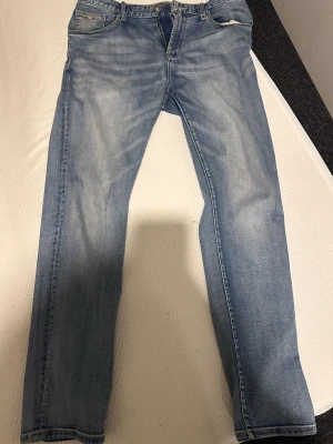 Blå jeans från Emporio Armani - Snygga blå jeans från Emporio Armani med klassisk femficksdesign och metallogo på fickan. Jeansen har en rak passform och är tillverkade i mjukt denimtyg. Perfekta för dig som gillar stilrena och tidlösa jeans med exklusiv känsla.