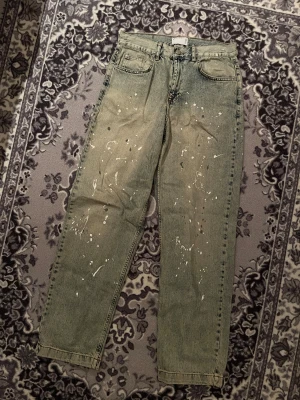 Ljusblå jeans med färgskvätt - Relaxed jeans med färgskvätt på i storleken W32 L34 perfekta för att göra en tråkig outfit mer intressant! Jeansen är relaxed fit så sitter åt det mer lösa hållet och är i princip i nyskick, endast använda någon enstaka gång.