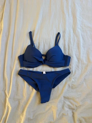 Marinblå Bikini💘 - En marinblå bikini i storlek S från Nelly💋(färgen ser klarare ut på bild, färgen visas bättre på andra bilden✌🏻) Toppen är pusch up och nederdelen har scrunch🥰