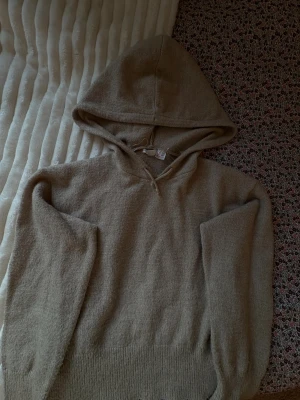 Beige stickad hoodie med huva - Mysig beige stickad hoodie med huva och långa ärmar. Tröjan är ribbad ner till och vid handlingarna och har en avslappnad passform, perfekt för kyliga dagar❄️. Använd få tal gånger🩷Är i stl 158/164 ungefär xs💕