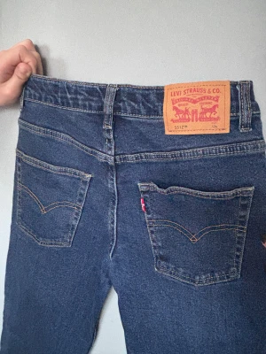 Levi's 551Z Straight jeans mörkblå 12A - Säljer ett par Levi's 551Z Authentic Straight jeans i mörkblå tvätt. Klassisk femficksmodell med raka ben och snygga kontrastsömmar. Märkespatch baktill och röd Levi's-tag på bakfickan. Perfekt för dig som gillar tidlös denimstil.