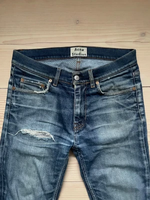 Acne Studios - Snygga jeans från Acne Studios, storlek W30 L32, slim fit. De har slitningar men är lagade så det är inget hål rakt igenom. Pris kan absolut diskuteras! Hör av er vid frågor eller funderingar!