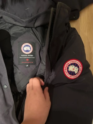 Svart Canada Goose parkajacka med päls - Säljer nu min mammas gamla canada goose jacka😂😇 storlek L i kvinna (kan ha som man oxå) ÄKTA‼️den är lite små smutsig osv. Tror inga hål‼️Skickas samma dag som köp‼️ för frågor osv skriv till min från denna annons🤩🙏