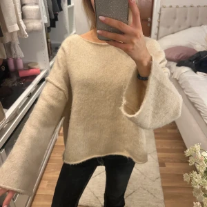 Beige stickad tröja - Mysig beige stickad tröja med en loose passform och långa ärmar. Perfekt för kyliga dagar när du vill ha något bekvämt och stilrent. Passar bra till jeans eller leggings för en avslappnad look. Har tagit bort storlekslappen i nacken då den syntes men annars inga tecken på användning.