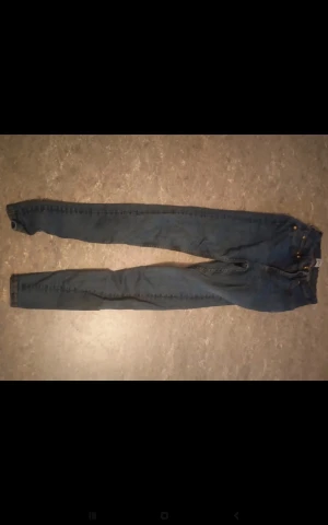 Mörkblå skinny jeans - Snygga mörkblå skinny jeans med klassisk femficksdesign och dragkedja fram. Jeansen har en smal passform som sitter tight längs benen och är tillverkade i jeansmaterial. Perfekta för dig som gillar en stilren och enkel look.