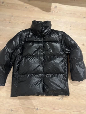 Svart pufferjacka med hög krage - Säljer en svart Arket pufferjacka med hög krage. Oversized modell storlek M. Jackan är mer som en lättvikts dunjacka. Passar även mig som har storlek s om man vill att den ska vara mer oversized. 