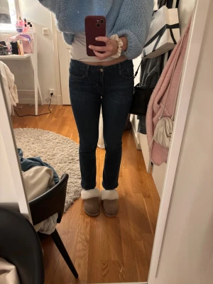 Frame Le Crop Mini Boot jeans blå - Snygga mörkblå jeans från Frame, modell Le Crop Mini Boot. De har klassisk femficksdesign, smal passform upptill och lätt utsvängda ben. Jeansen är midwaist och tillverkade i mjukt denim med stretch för extra komfort. Säljer pågrund av att de är för korta för mig, jag är 165