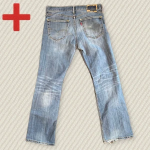 Levis 527 Bootcut  - Ett par riktigt fina Levis 527 Bootcut jeans i bra skick! Storlek 34/32. Baktaggen har gått sönder och lite heelbite. Skriv om du har frågor!  Mått: Midja – 44 cm, Lår – 30 cm, Innersöm – 80 cm, Yttersöm – 105 cm, Benöppning – 22,5 cm