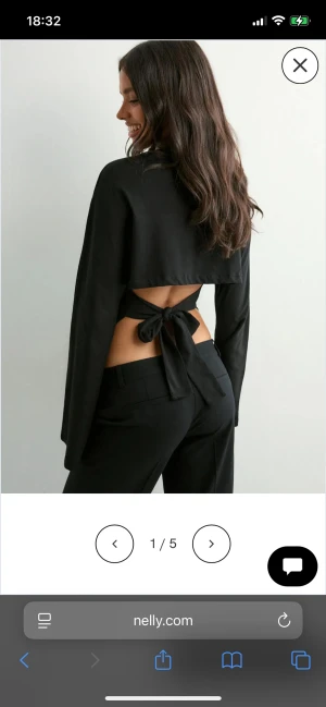 Svart långärmad topp med öppen rygg från Nelly - Säljer en svart långärmad topp från Nelly i storlek XS. Toppen har en snygg öppen rygg med knytband och croppad passform. Materialet är mjukt och stretchigt, perfekt för att skapa en cool och trendig look. Passar dig som gillar stilrena plagg med en twist.